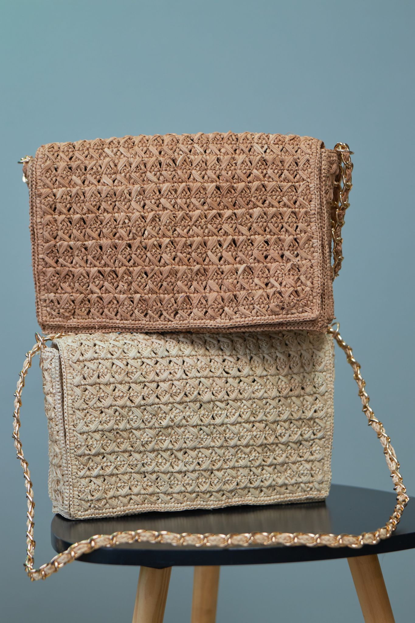 Two hand-crocheted raffia shoulder bags, showing the intricate natural fibre stitch